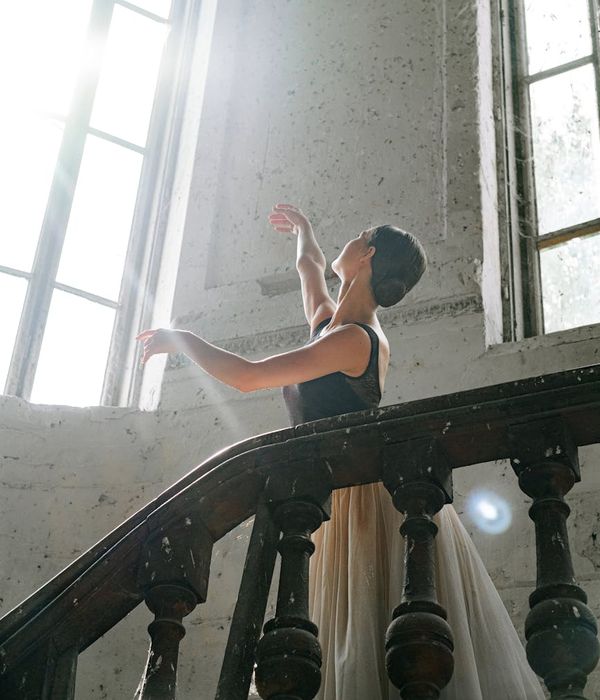 Woman in activewear performing a light cardio movement with a serene expression.